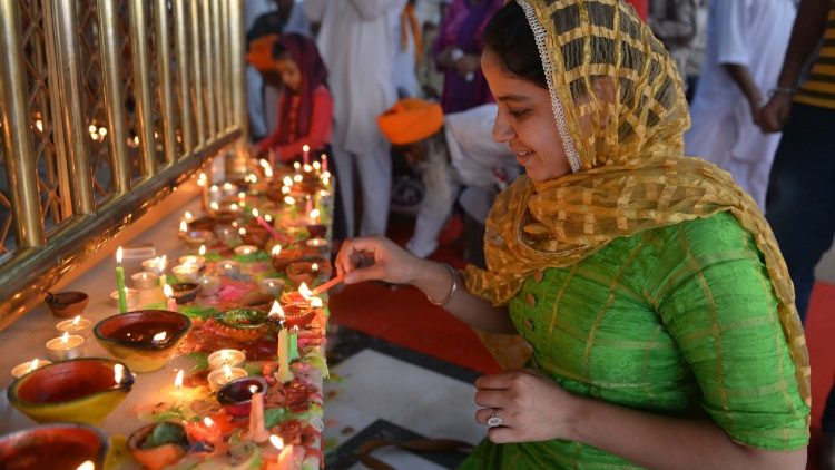 Woman in India lights a lamps for Deepavali