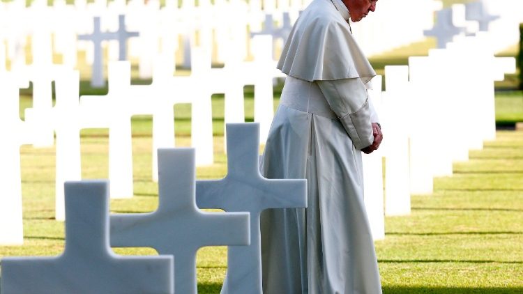Pope Francis lays white roses on tombs at the US war cemetery in Nettuno south of Rome before celebrating Mass.