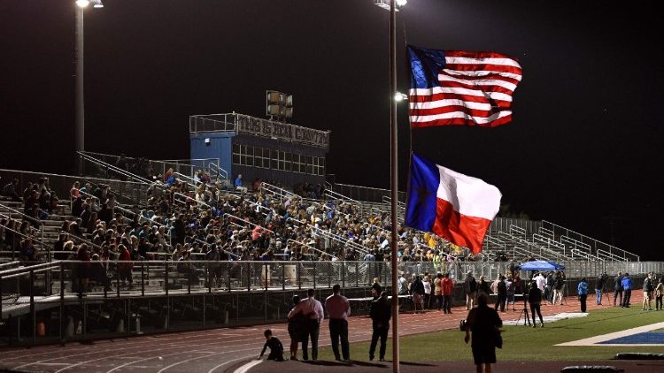 A file photo of the American and Texan flags flying at half-mast in a football stadium