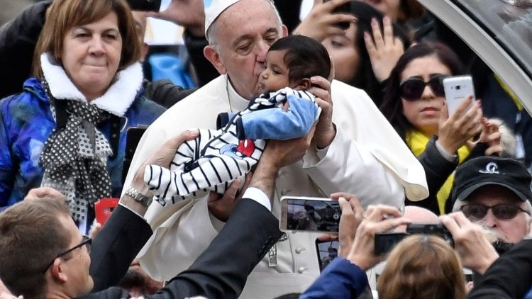 Pope Francis kisses baby at general audience