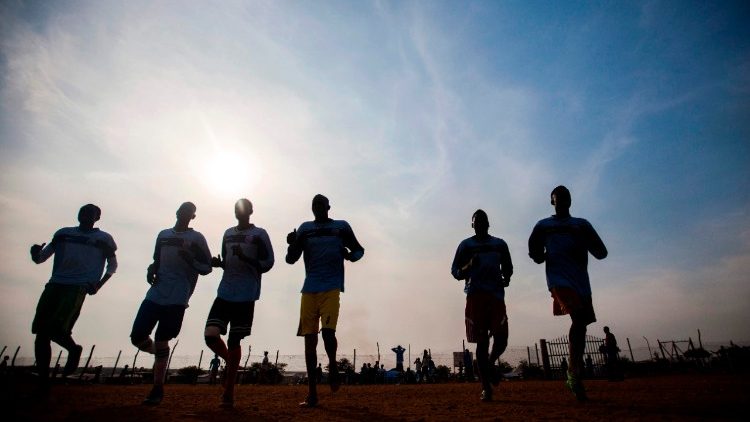 Young displaced men play football in a UN Protection of Civliians site in Juba