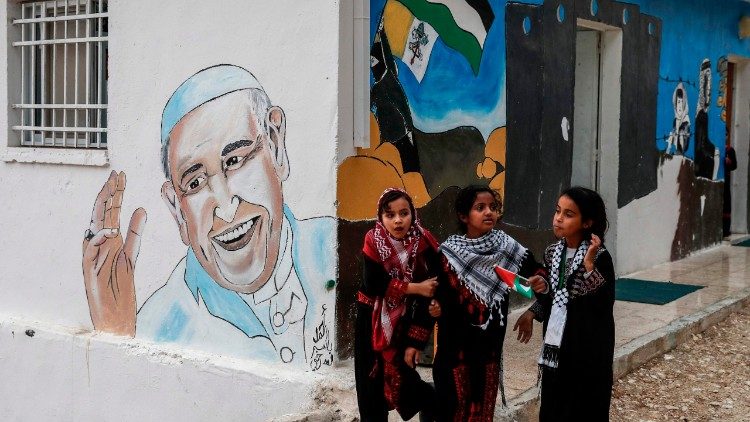 Palästinenserinnen in einem Flüchtlingslager in der Nähe von Jericho vor einem Papst-Wandbild