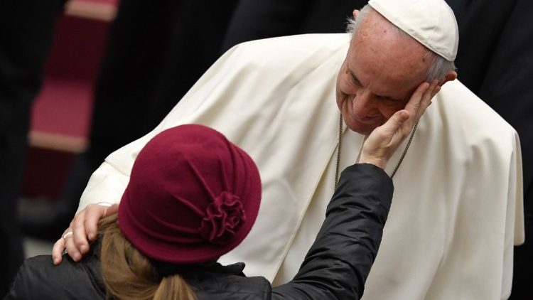 Papa Francesco riceve una carezza da una donna, durante un'udienza generale