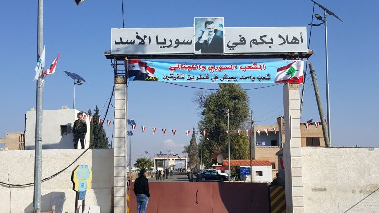 Grenzübergang vom Libanon nach Syrien. Auf dem Plakat steht: Willkommen in Assads Syrien!