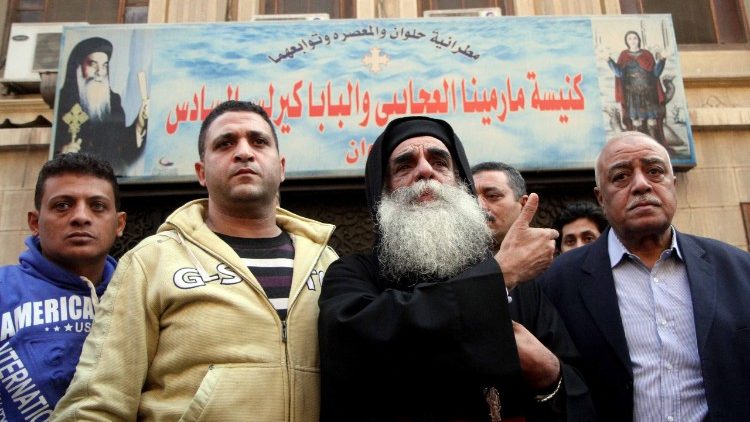 Egyptians react as they stand outside the Mar Mina Church south of Cairo following a gun attack on Friday.
