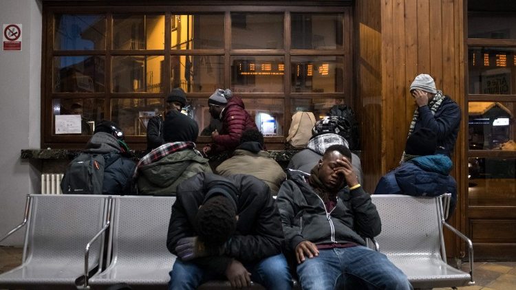 Migrants waiting at a train station in Italy.