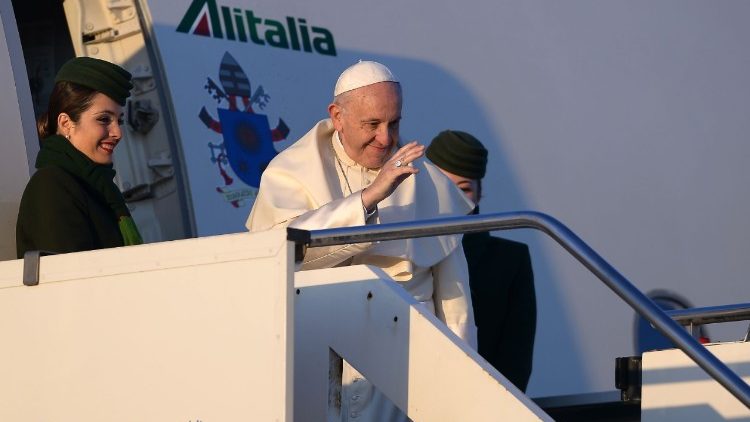 Pope Francis waves from the door of the Alitalia plane that is taking him to South America.