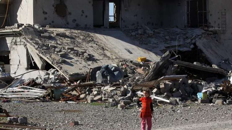 Criança no povoado de Baz Gerkan, próximo à Mosul, em meio à ruínas de prédio destruído pelo Estado Islâmico