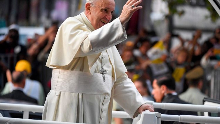Pope Francis waves at the crowds from the Popemobile in Santiago