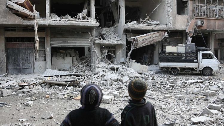 Des enfants à Arbin, dans la Ghouta oriental, devant les ruines d'un bâtiment bombardé