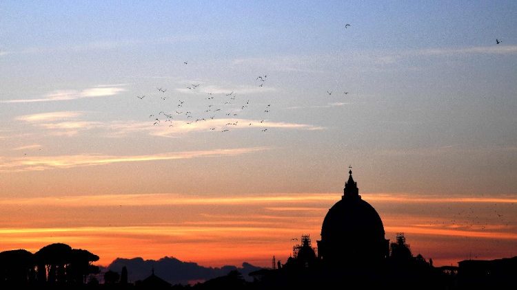 Sun sets over the cupola of St. Peter' Basilica Vatican