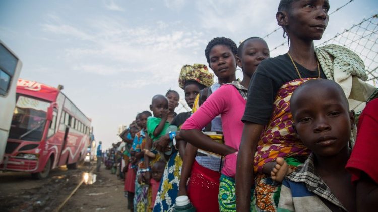 Flüchtlinge aus der DR Kongo warten auf ihren Bustransport in ein ugandisches Flüchtlingscamp