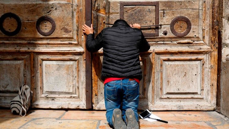 Un pèlerin agenouillé devant les portes closes du Saint-Sépulcre, ce dimanche 25 février
