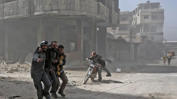 Helfer stützen einen verletzten Mann im syrischen Ost-Ghuta 