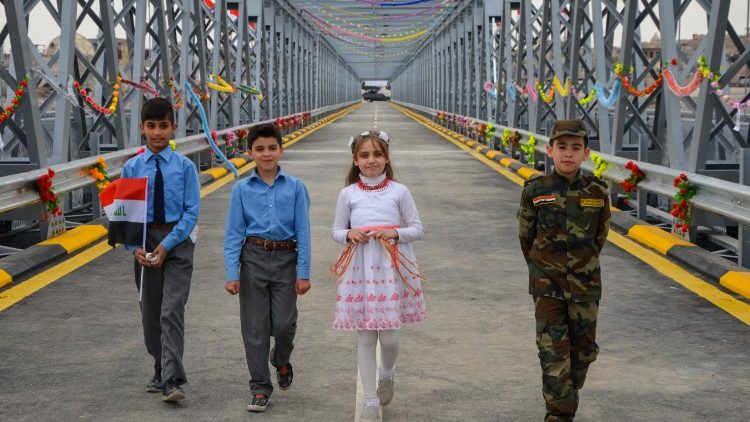 Иракски деца преминават през моста на Ниневия, познат като стария мост на Мосул