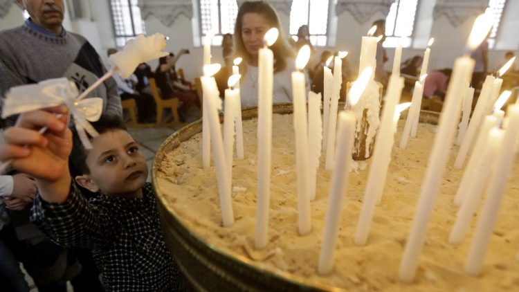 أطفال يضيئون الشموع في إحدى الكنائس السورية