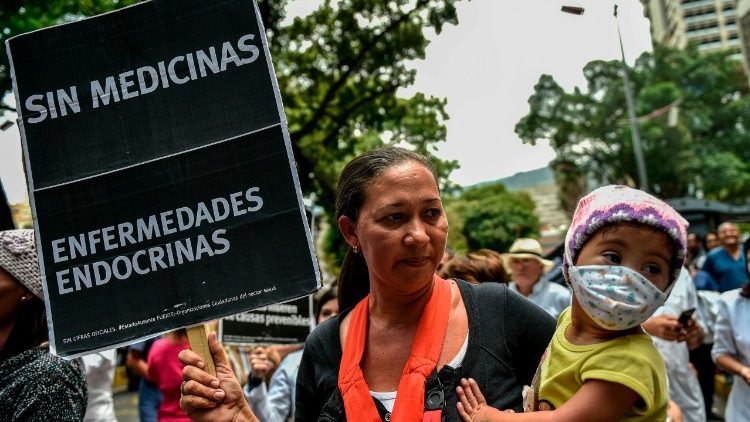 A Venezuelan woman with her sick daughter takes part in a protest by health workers and patients for the lack of medicines, medical supplies and poor conditions in hospitals 