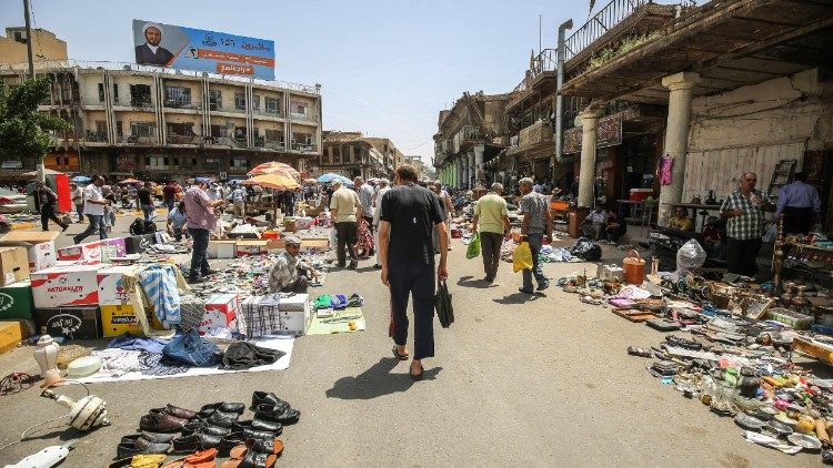 Menschen spazieren über einen Markt in Bagdad 