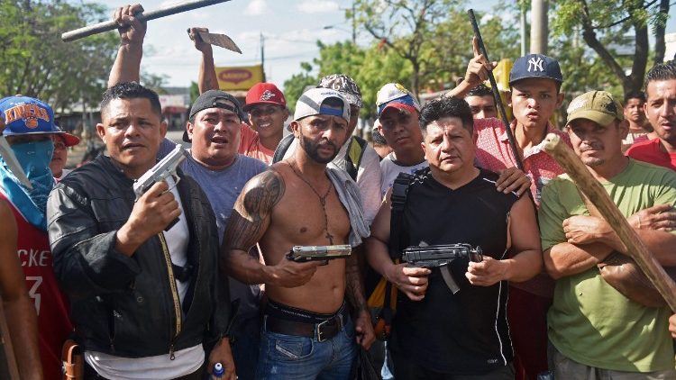 Armed shopkeepers in Managua guard their businesses amid lootings during protests against the government's pension reforms