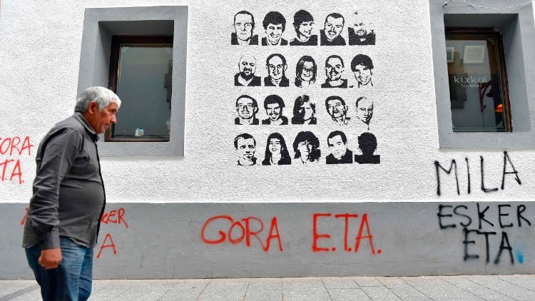 Čovjek hoda ispred portreta baskijske organizacije ETA