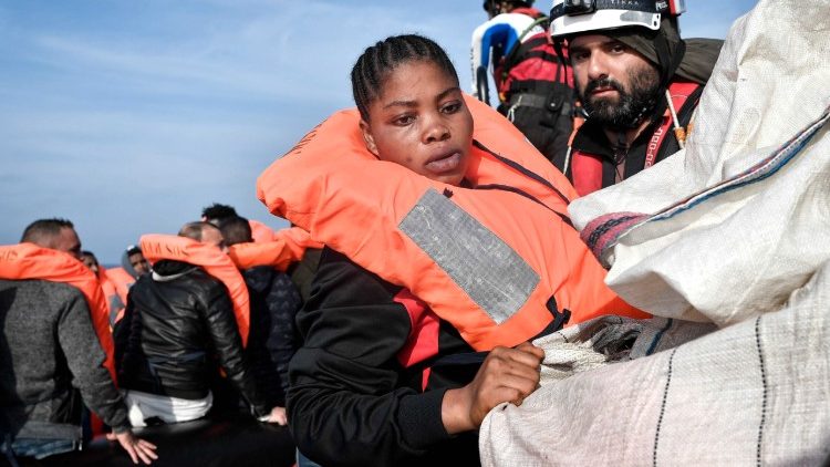 A pregnant woman is transferred to the rescue boat during a rescue operation off the Libyan coast