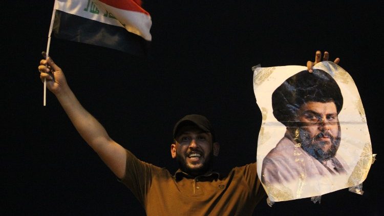 Un cittadino sventola una foto che ritrae Muqtada al Sadr 