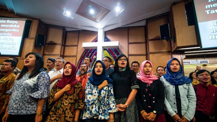 Indonesians from various religious backgrounds pray for victims of a bomb attack on a church. 