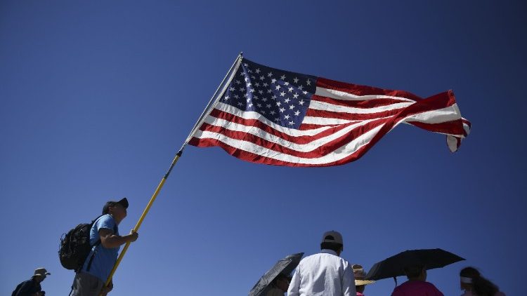 Demonstrator waving American flag at a rally on immigration