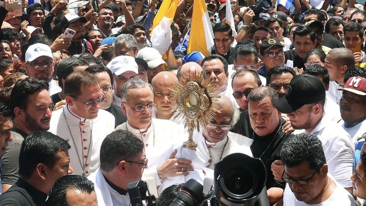 Cardinal Leopoldo Brenes holds the Blessed Sacrament in a crowd of worshipers