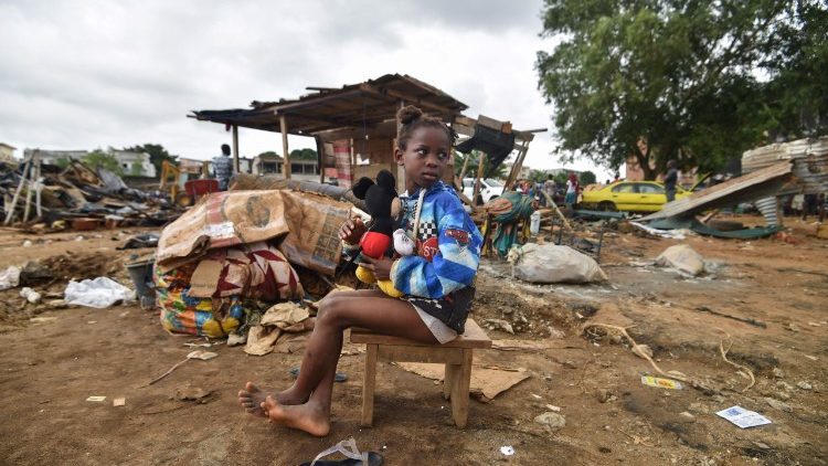 Une petite fille ivoirienne s'accrochant à sa peluche alors que sa maison vient d'être détruite par l'opération bulldozer décidée à la suite des innondations, le 23 juin 2018. 