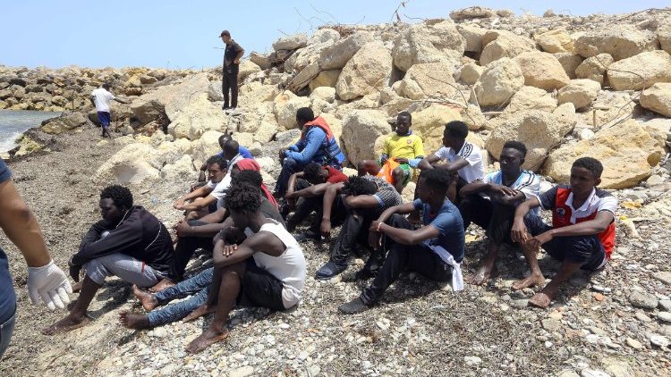Migrants who survived the sinking of an inflatable dinghy boat off the coast of Libya on the shore of al-Hmidya