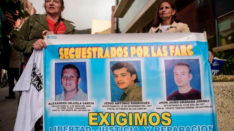 Frauen halten Banner mit Fotos von Männern, die von FARC-Guerilla entführt worden sind.