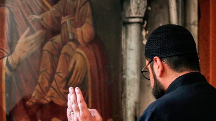 Sacerdote siríaco-ortodoxo reza diante de ícone de Nossa Senhora Eleusa, na cidade de Fairouzah