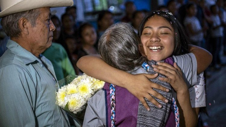 मैक्सिको की एक बालिका अपने दादी को गले लगाते हुए