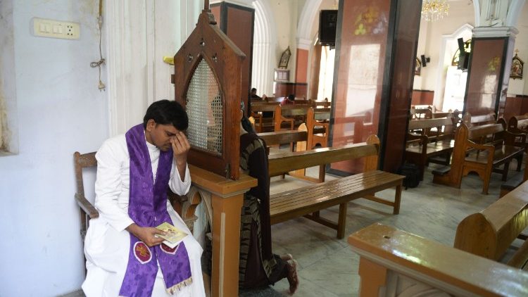 Sacerdote indiano atende confissão na Basílica Santa Maria, em Secunderabad