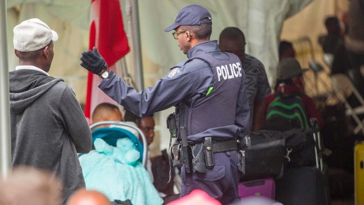 Un policier canadien s'adressant à des migrants illégaux après leur traversée de la frontière au Québec, en août 2017.