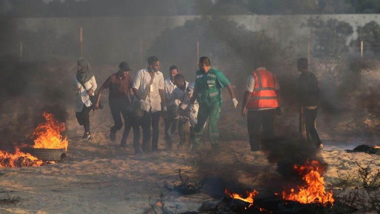 مسعفون يحملون عددا من المتظاهرين المصابين في غزة