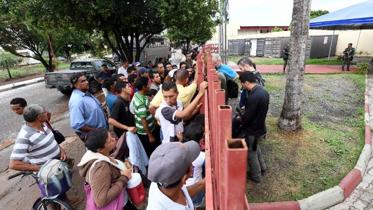 Flüchtlinge aus Venezuela stehen vor dem Eingang eines Lagers in Brasilien Schlange