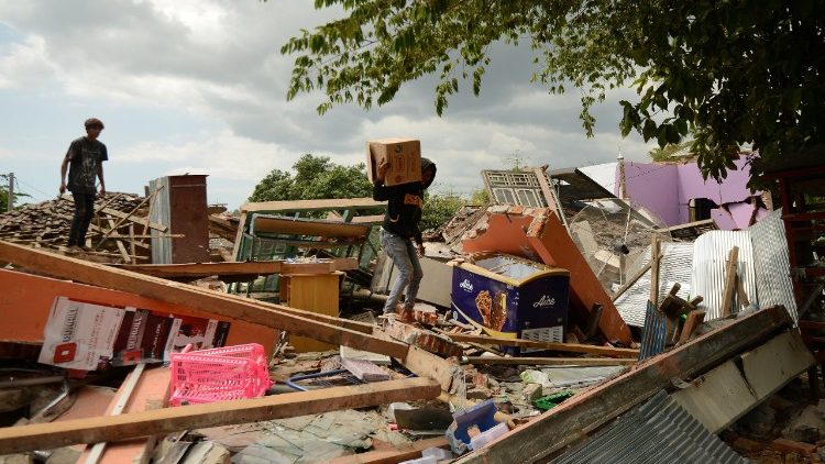 Recherche de biens dans une maison effondrée à Kayangan, sur l'île de Lombok, en Indonésie.