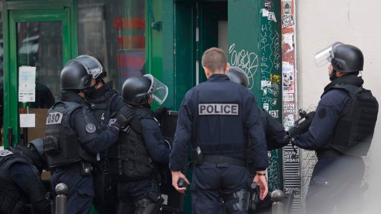 French Police officers enter a building during a police operation in Paris