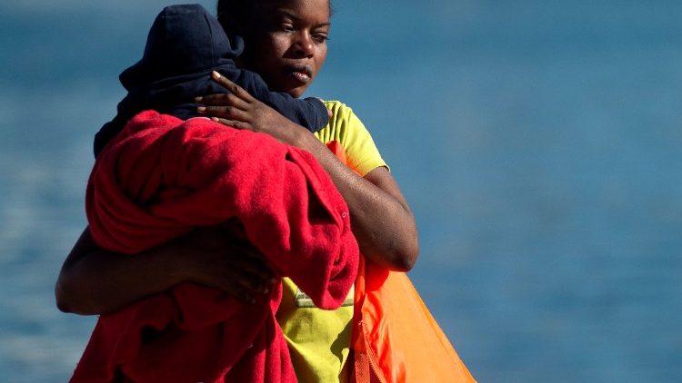 Lo sbarco di una migrante con il suo bambino