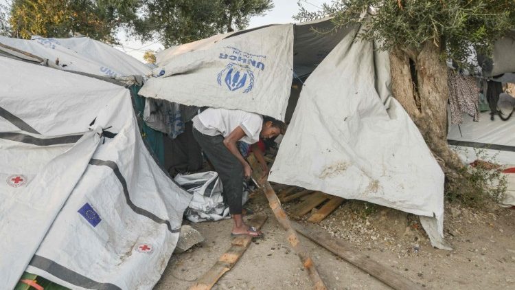 A  man fixes his tent in a camp outside of the refugee camp of Moria on the island of Lesbos