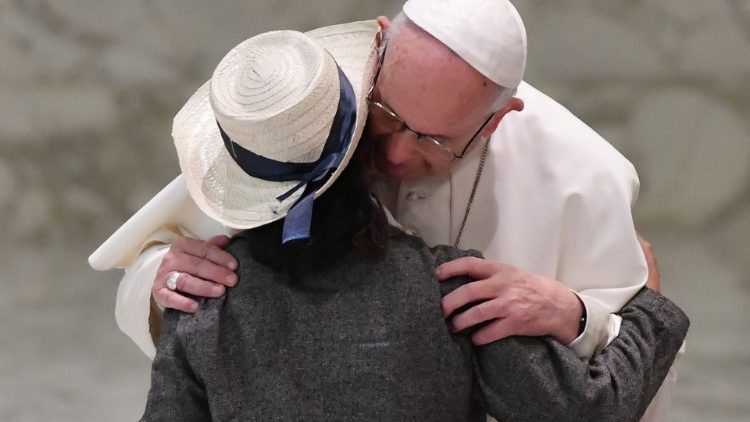 Papst Franziskus umarmt eine junge Frau