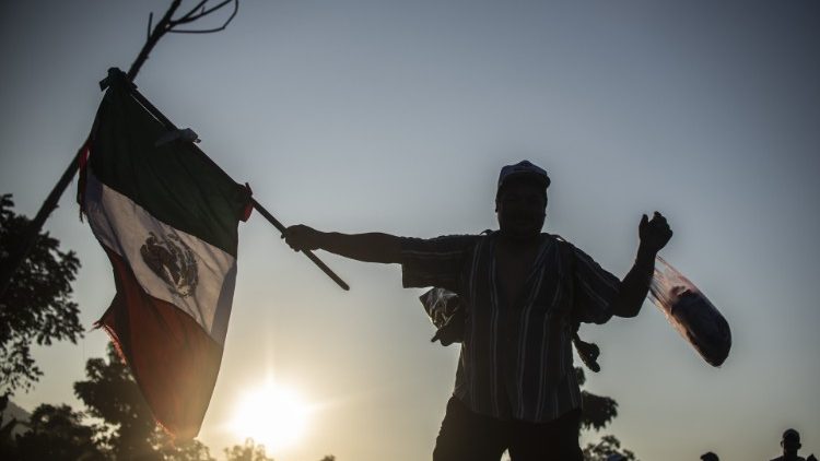 A Honduran migrant heading to the US waves a Mexican flag