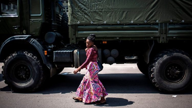 Frau vor Militärfahrzeug in der Demokratischen Republik Kongo