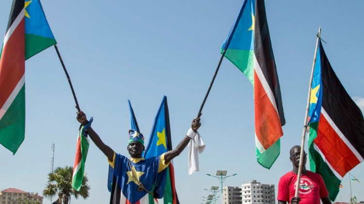 Manifestantas už taiką Džuboje laiko šalies vėliavas