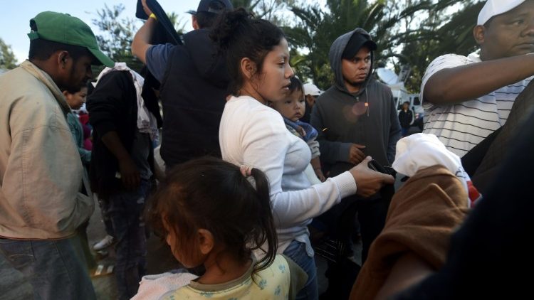 Central-American migrants queue to receive breakfast during a stop at a temporary shelter in Mexico City