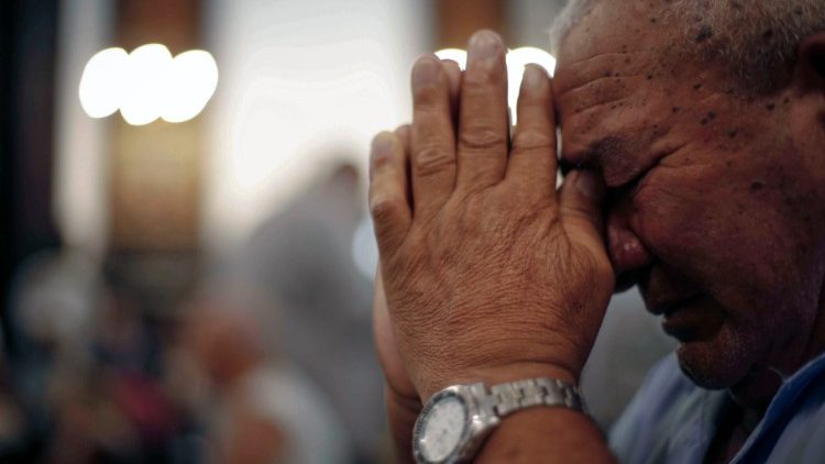 मृतकों की याद में कैम्पिनास महागिरजाघर में प्रार्थना करता व्यक्ति 