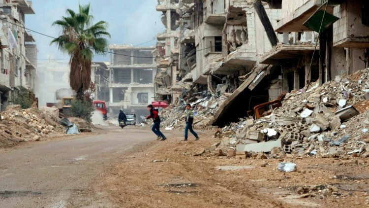 Dječaci se igraju među ratom razrušenim zgradama u Siriji