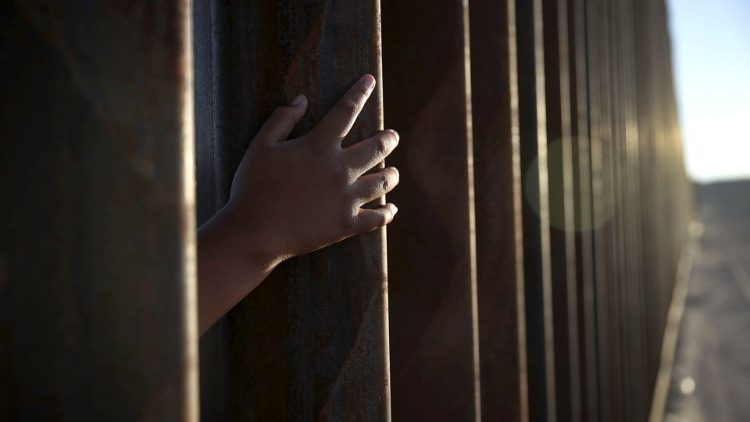 A child reaches through the border fence separating Mexico from Sunland Park, New Mexico 